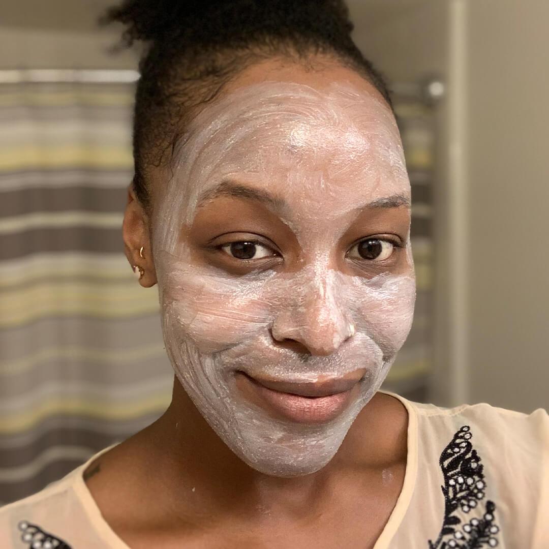 Close-up image of a smiling woman with mud mask on her face Desktop