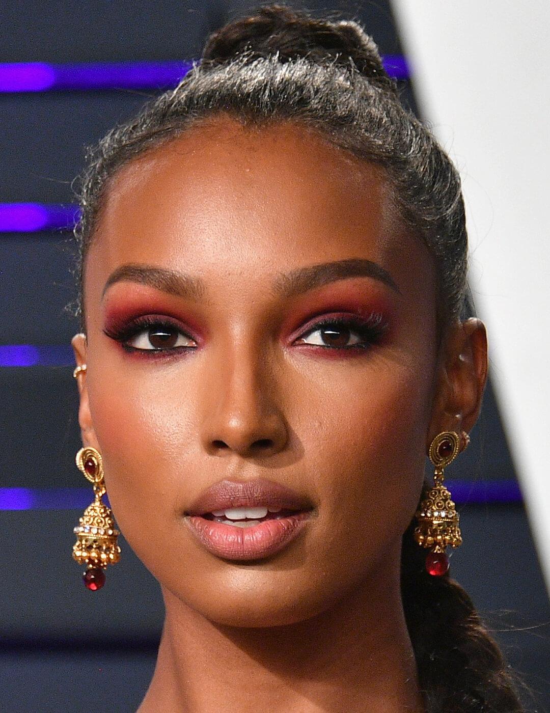 Close-up of Jasmine Tookes wearing a wine red eyeshadow makeup look and high ponytail hairstyle Mobile