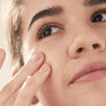 A closeup image of a model touching her cheek with two fingers Mobile