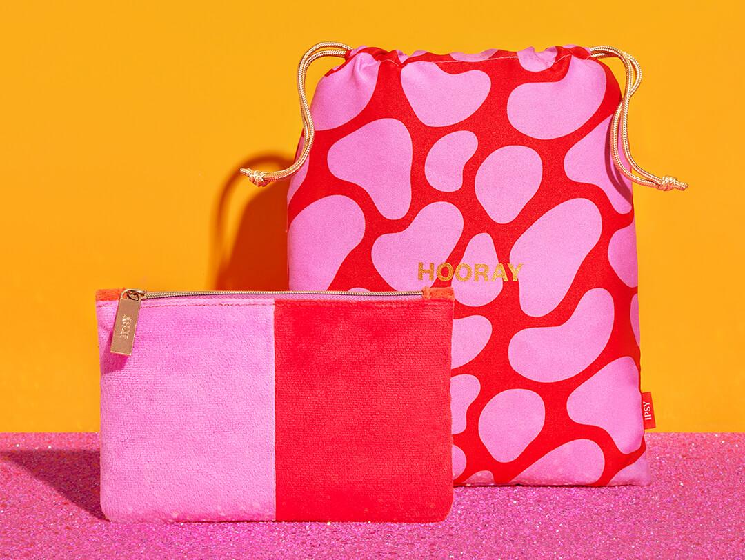 December 2022 IPSY Glam Bag and Glam Bag Plus bags on orange and pink glitter background Desktop