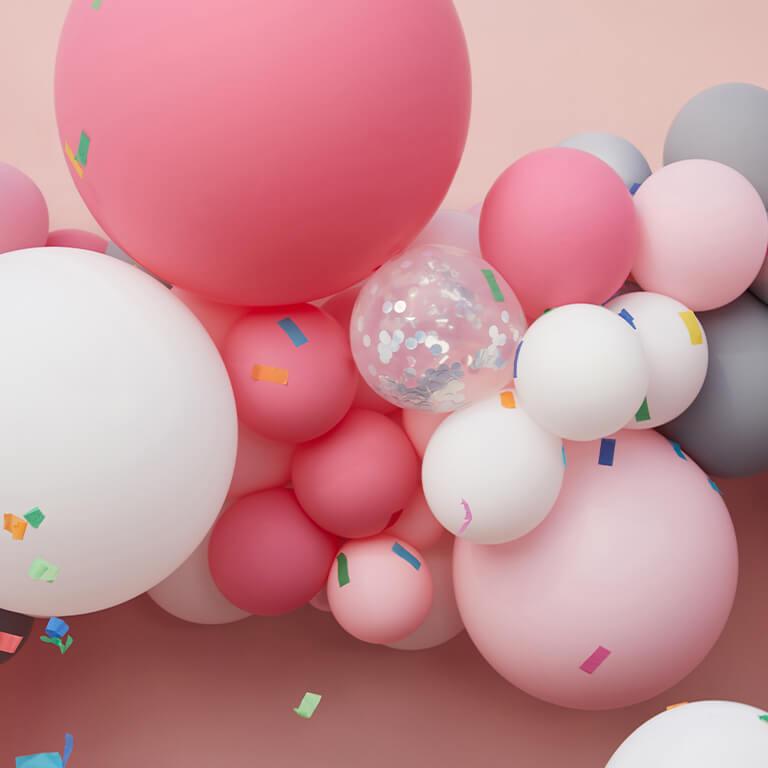 An image of pink and white balloons and confetti. Mobile