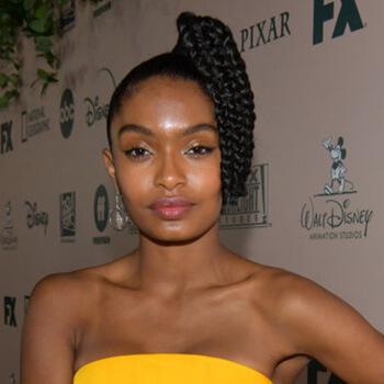 A close-up image of Yara Shahidi in a yellow tube dress rocking a braided side high pony tail hairstyle Mobile