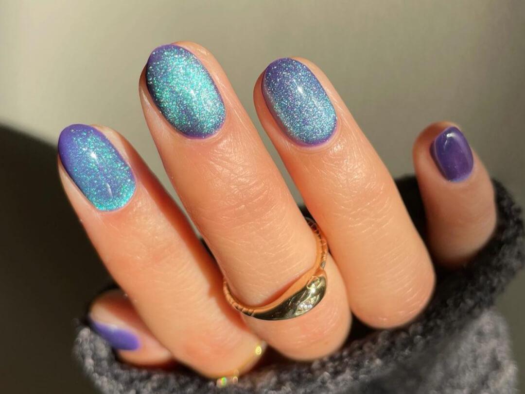 Close-up of a woman's nails with aquamarine and purple velvet nail art Desktop