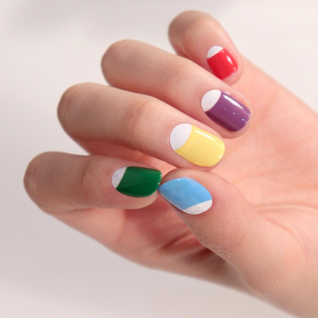 A closeup photo of a hand with a pastel half-moon mani Mobile