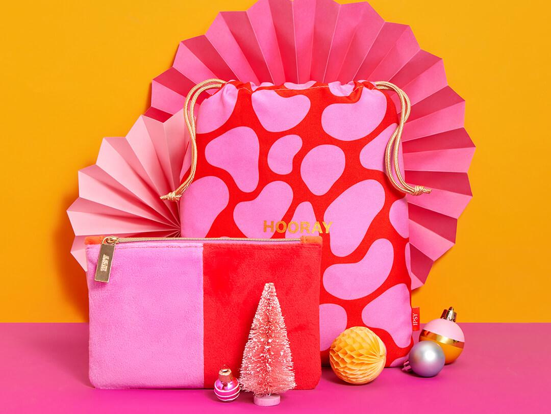 December 2022 IPSY Glam Bag and Glam Bag plus on orange and pink background with bright Christmas decors Desktop