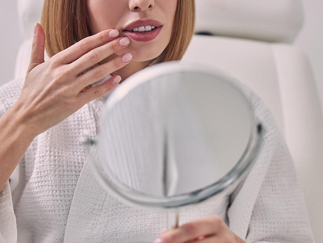 Woman in a white bathrobe checking her month in the mirror Desktop