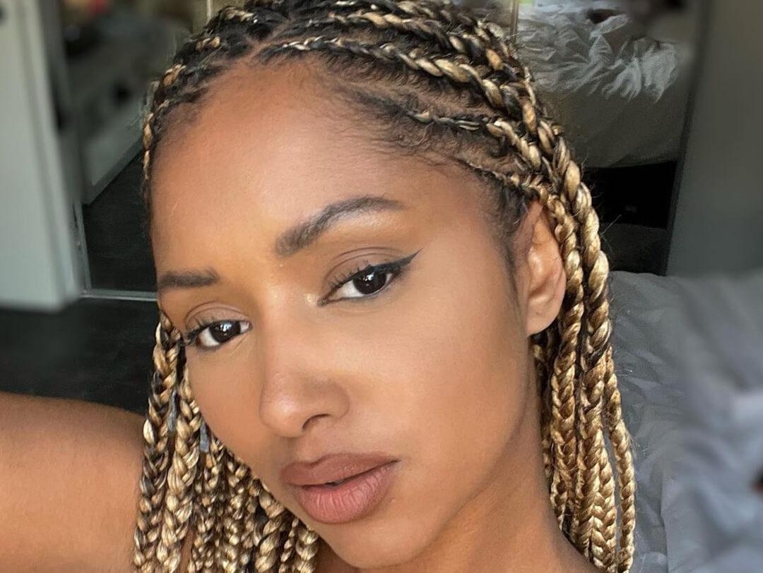 A closeup photo of a model with a blonde knotless braids hairstyle Desktop