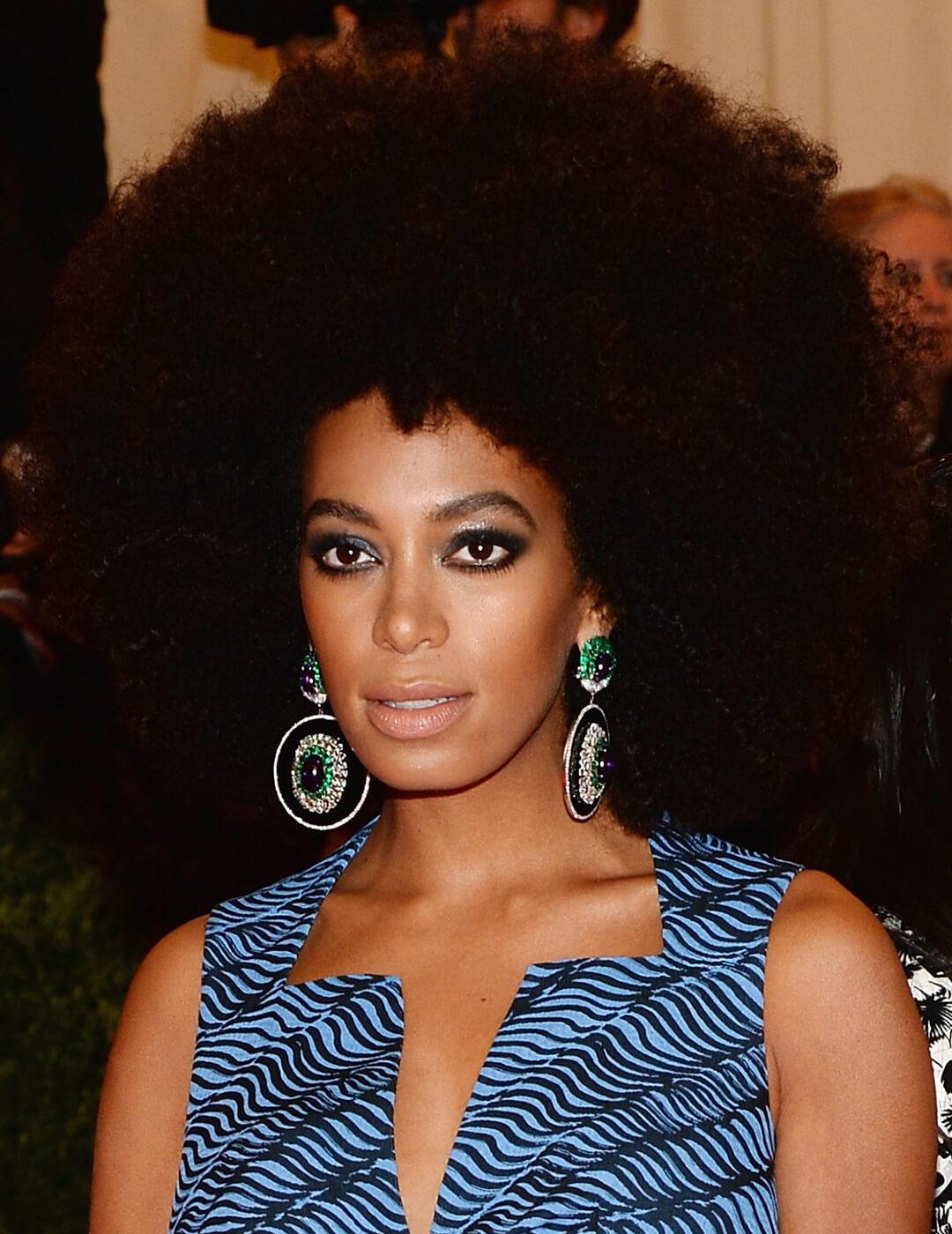 Solange Knowles rocking an afro hairstyle and groovy blue outfit Desktop