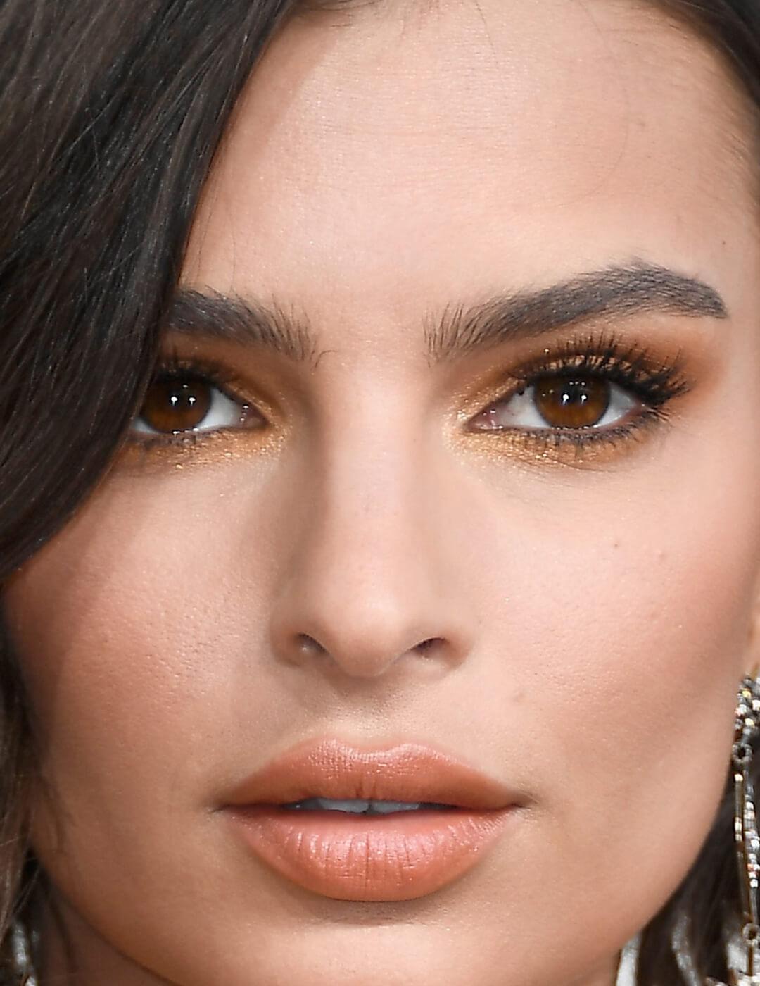 Close-up image of Emily Ratajkowski wearing a sultry gold eyeshadow makeup look Mobile