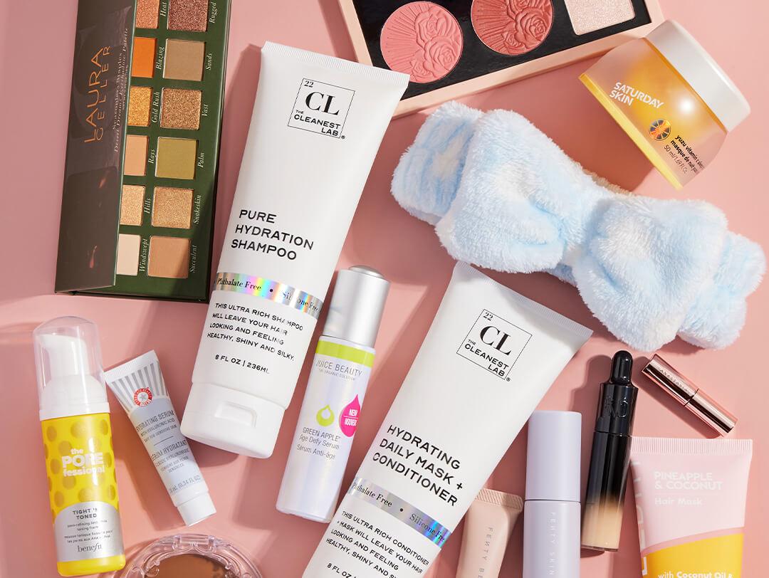 Beauty and makeup products from various brands scattered on coral peach background Desktop