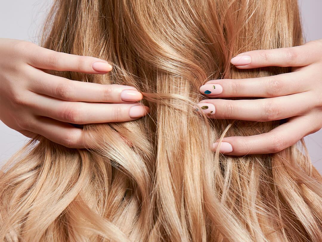 Image of a woman touching her strong blonde hair Desktop