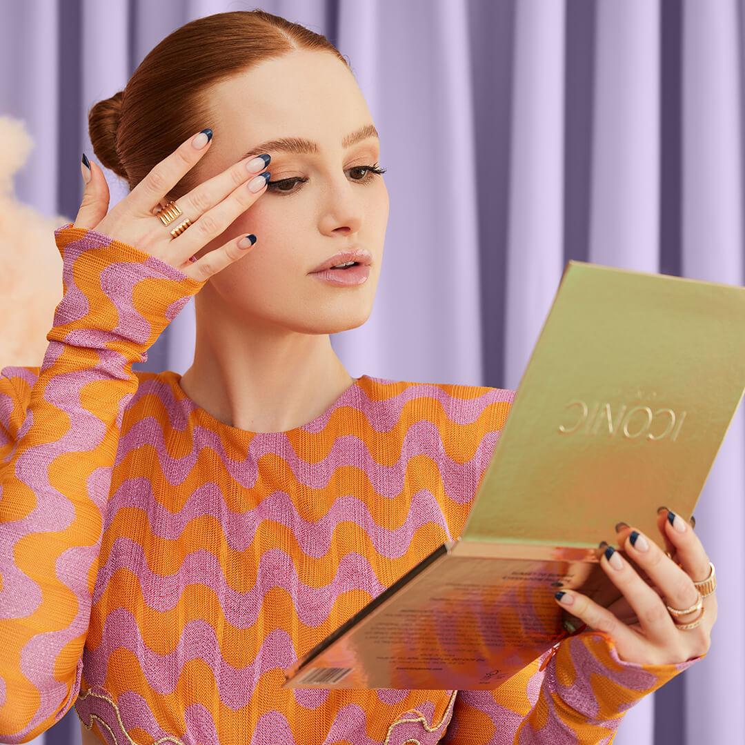 Image of Madelaine Petsch holding the ICONIC LONDON Sunset to Sunrise Eyeshadow Palette and touching her eyelid Desktop