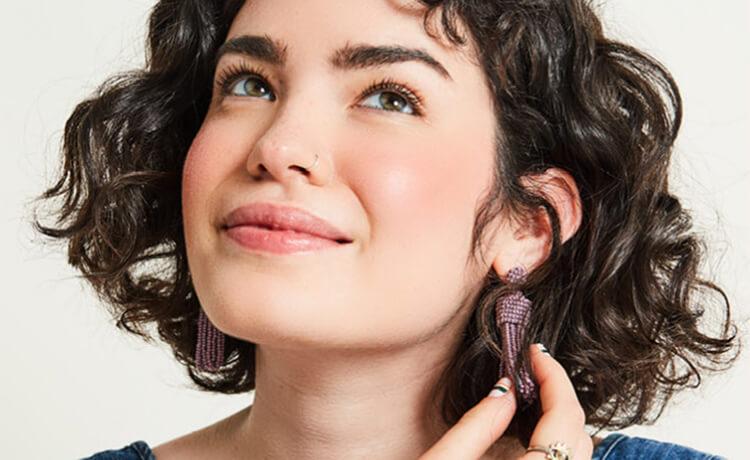 A model spritzes on some face mist. Desktop