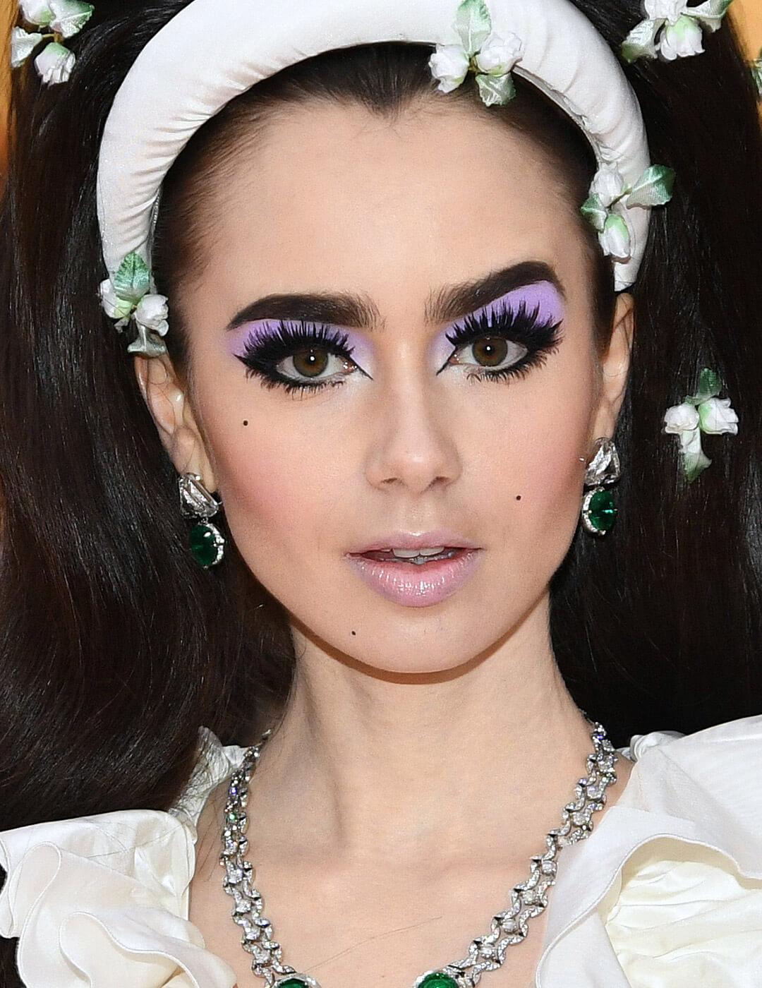 Lily Collins rocking pastel lilac eyeshadow and bold eyeliner and eyelashes makeup look Mobile
