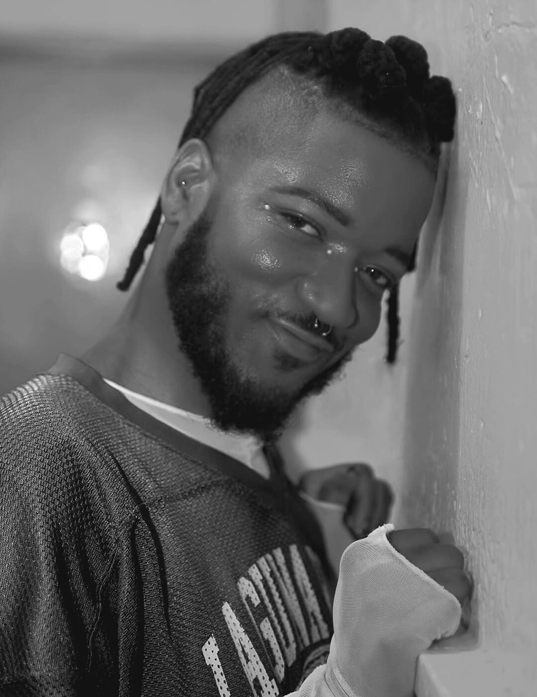 Black and white portrait of Bryce Anthony posing against a wall Mobile