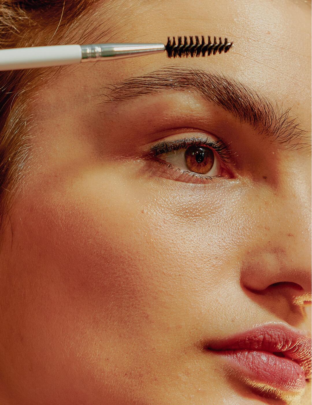 Portrait of Young Confident Woman Brushing Her Eyebrows Mobile