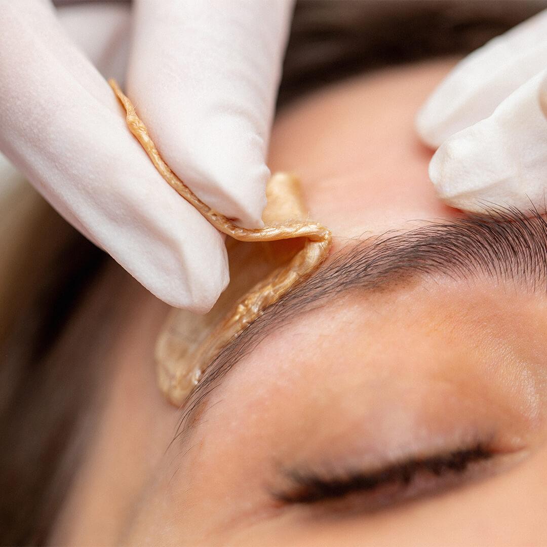 Close-up image of a woman's eyebrow being waxed Desktop