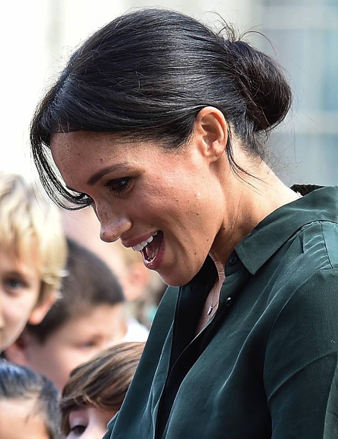 Meghan Markle, Duchess of Sussex, greeting children and sporting a messy chignon hairstyle Desktop