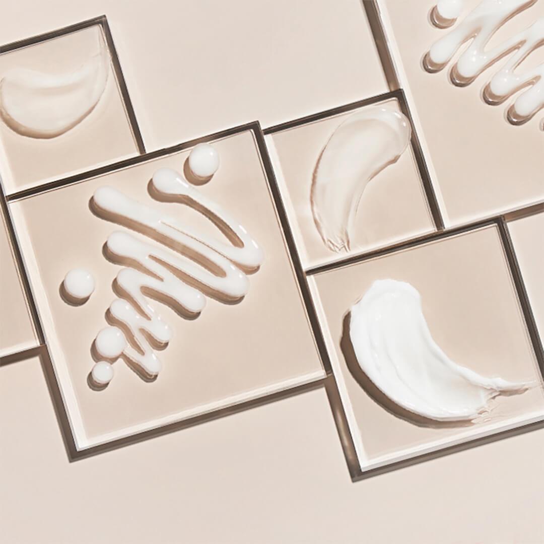 Different moisturizers and creams swatched in square frames on beige background Desktop