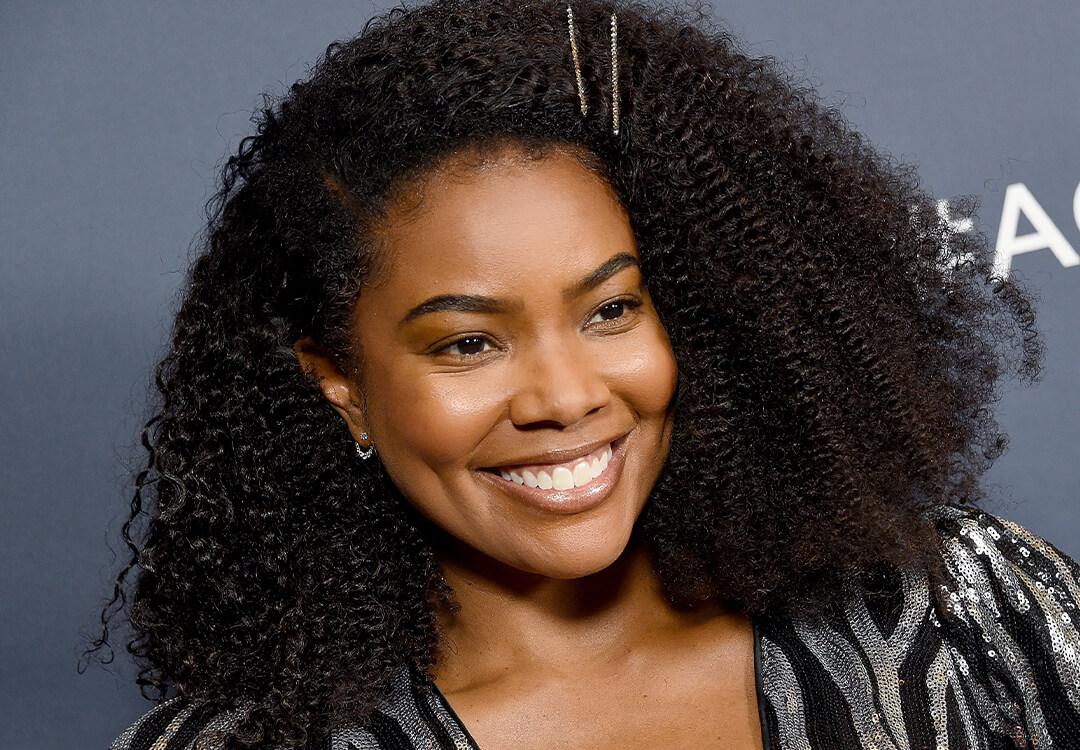 Gabrielle Union with a pinned back hairstyle smiling Mobile