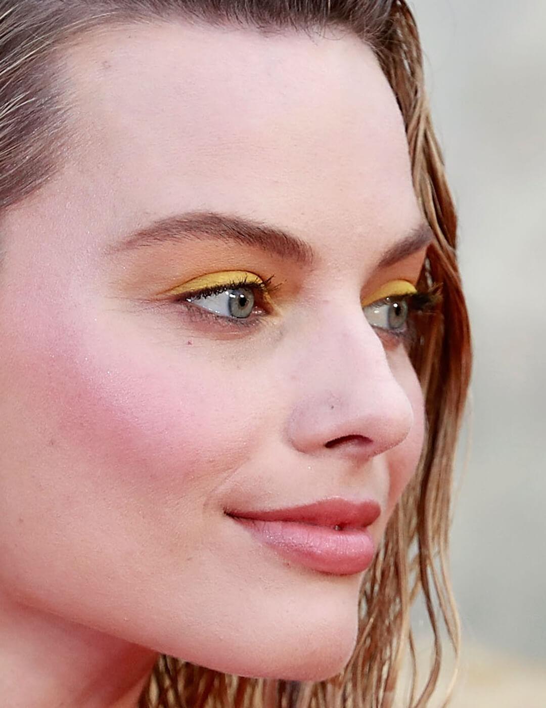 Close-up side profile image of Margot Robbie rocking a bright yellow eyeshadow makeup look Desktop