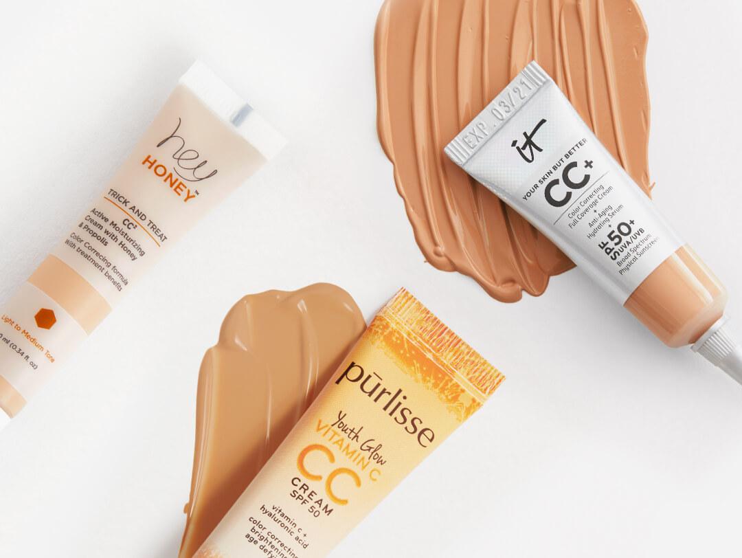 Three tubes of CC cream from various brands swatched on white background Desktop