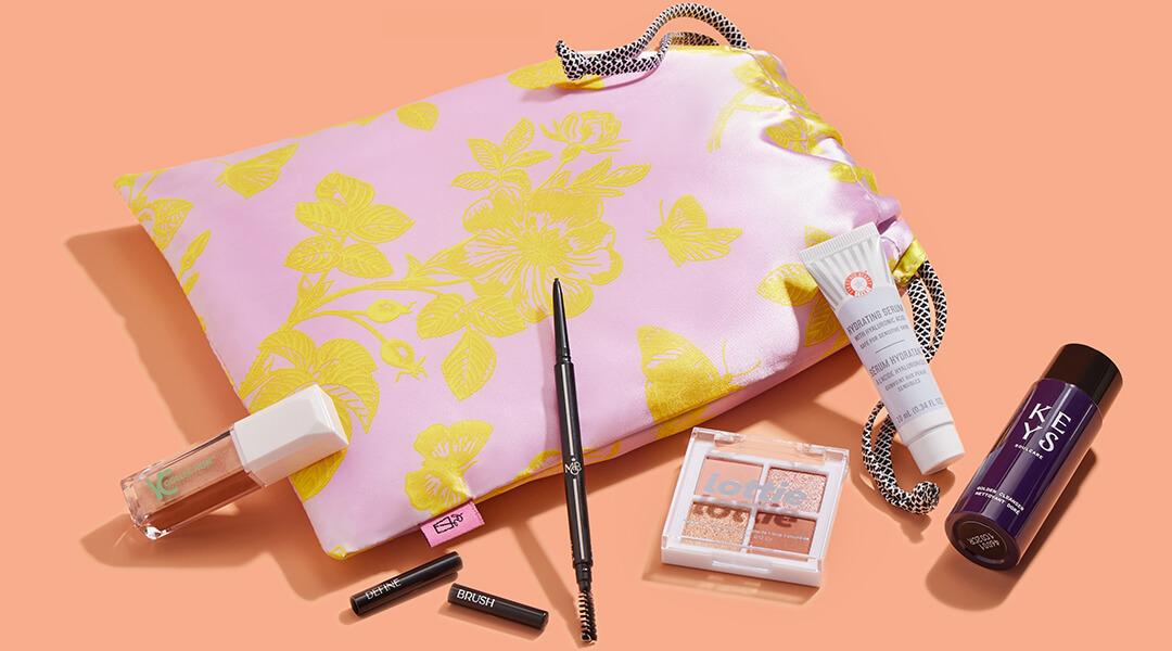 July 2023 IPSY Glam Bag and various beauty products on coral background Desktop