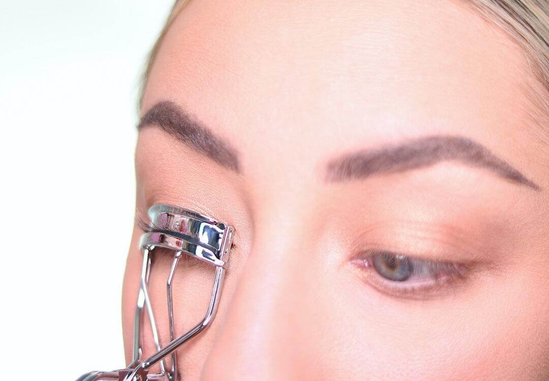 Close-up image of Anne Baker curling her lashes Desktop