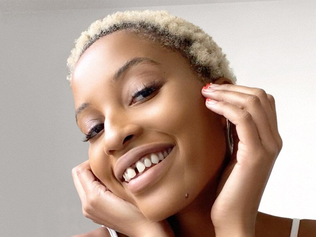 Close-up of a Black model with clear skin posing and smiling Desktop