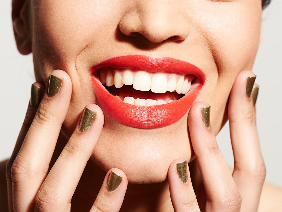 An upclose photo of a smiling woman wearing a red lipstick Desktop