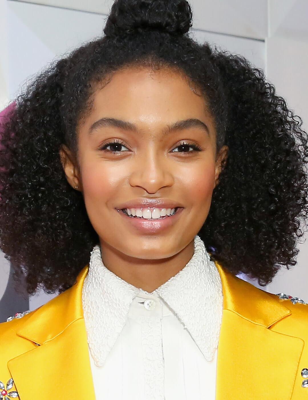 A photo of Yara Shahidi with a curly half-bun hair Mobile