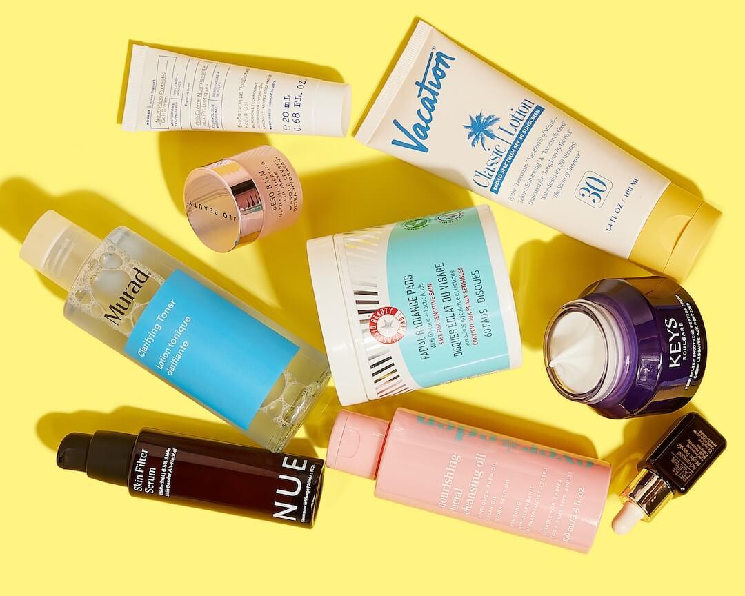 Flat lay image of skincare products from various brands on colorful yellow background Desktop