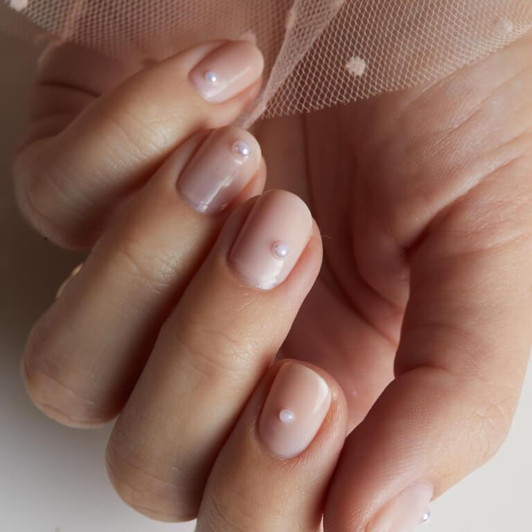 An image of a nude pink nail mani with pearl accents Mobile