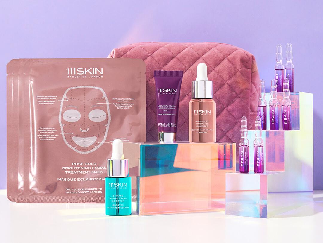 Beauty and skincare products from 111SKIN arranged on chromatic boxes against purple background Desktop