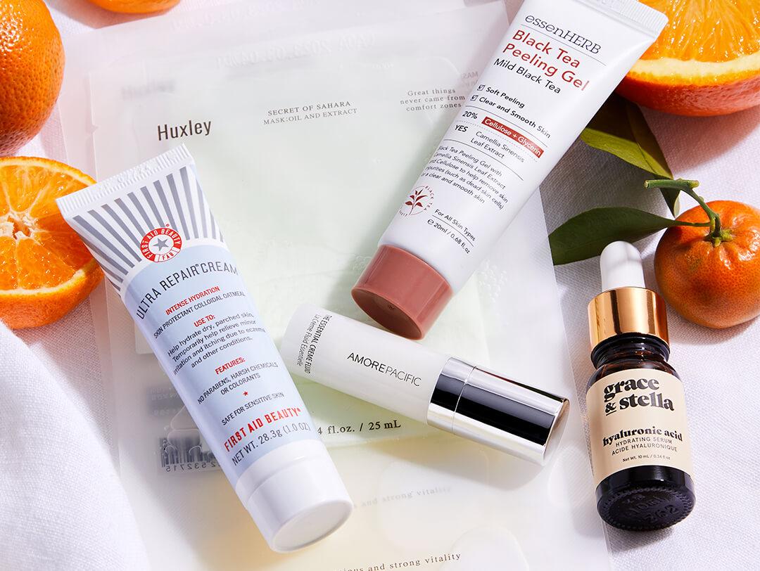 Flatlay image of skincare products from various brands with oranges Desktop
