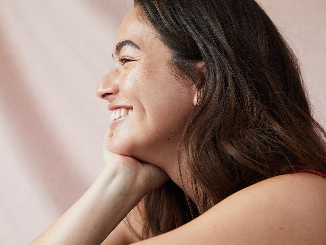Close-up profile image of a model posing while smiling big Desktop