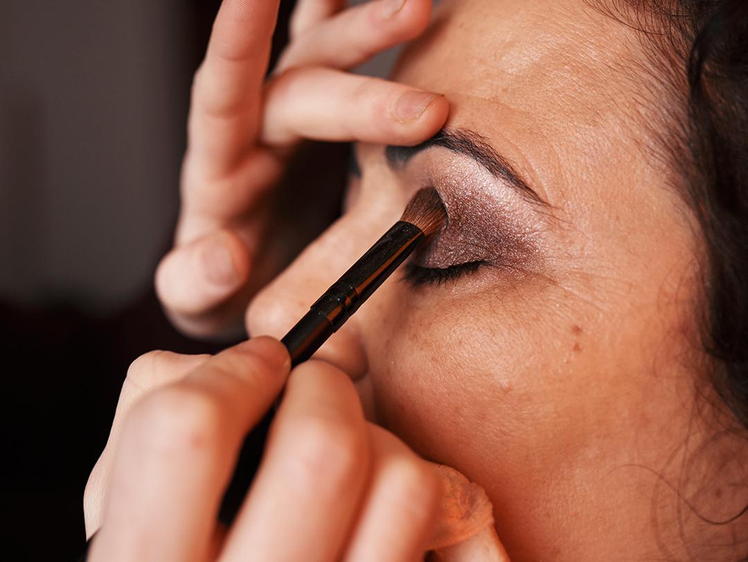 Closeup shot of a makeup artist applying smokey eyeshadow with a black brush Desktop