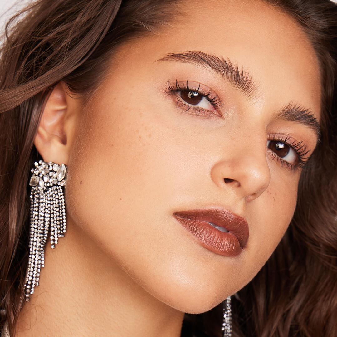 Close-up of a model rocking minimalist eyeshadow makeup paired with dark red lips Desktop