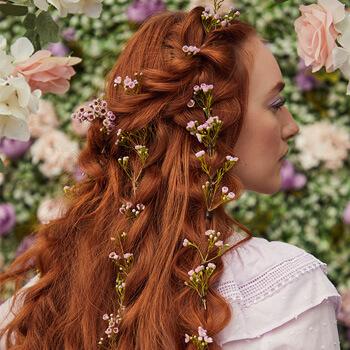 A close-up image of a red-haired model's bubble braids with flower stems Mobile