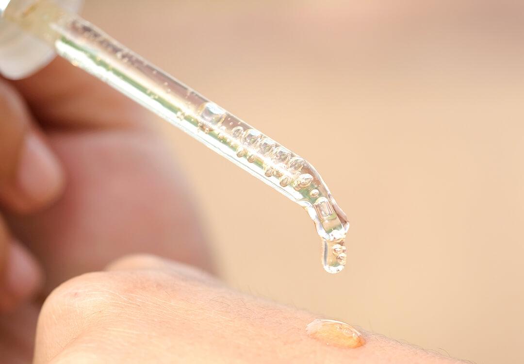 An image of a dropper with clear liquid on skin Mobile