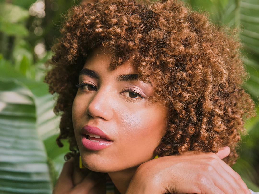 A photo of a model's face with healthy looking skin on a nature background Desktop