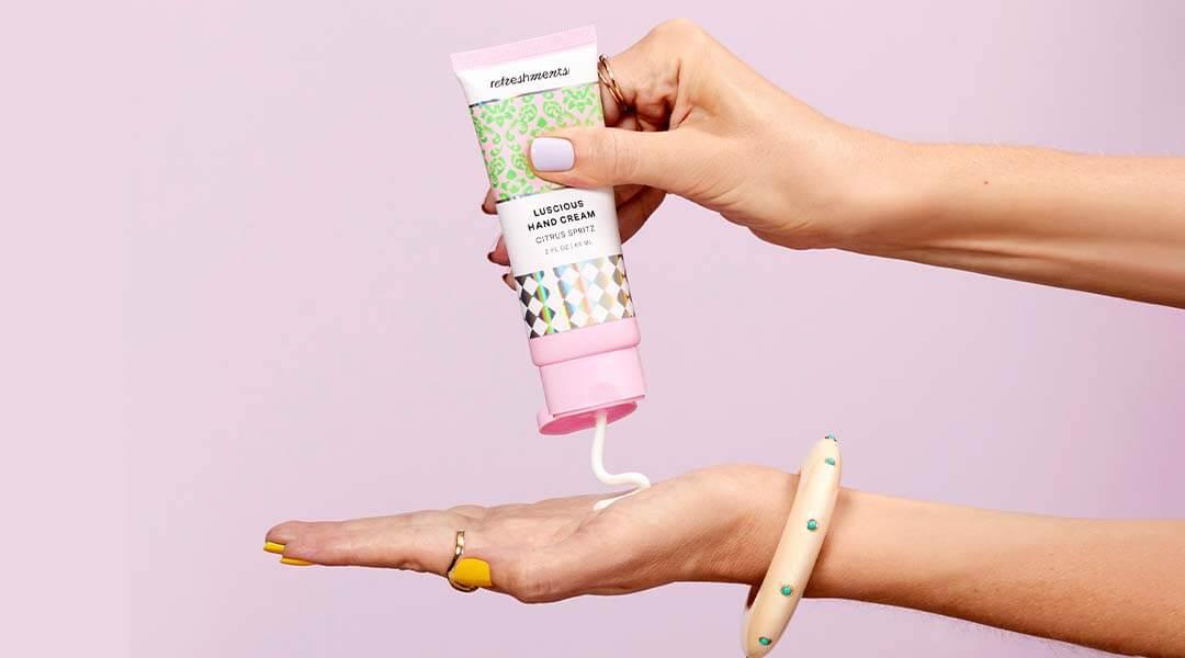 Close-up of model's hands squeezing onto her palm REFRESHMENTS Luscious Hand Cream in Citrus Spritz Desktop