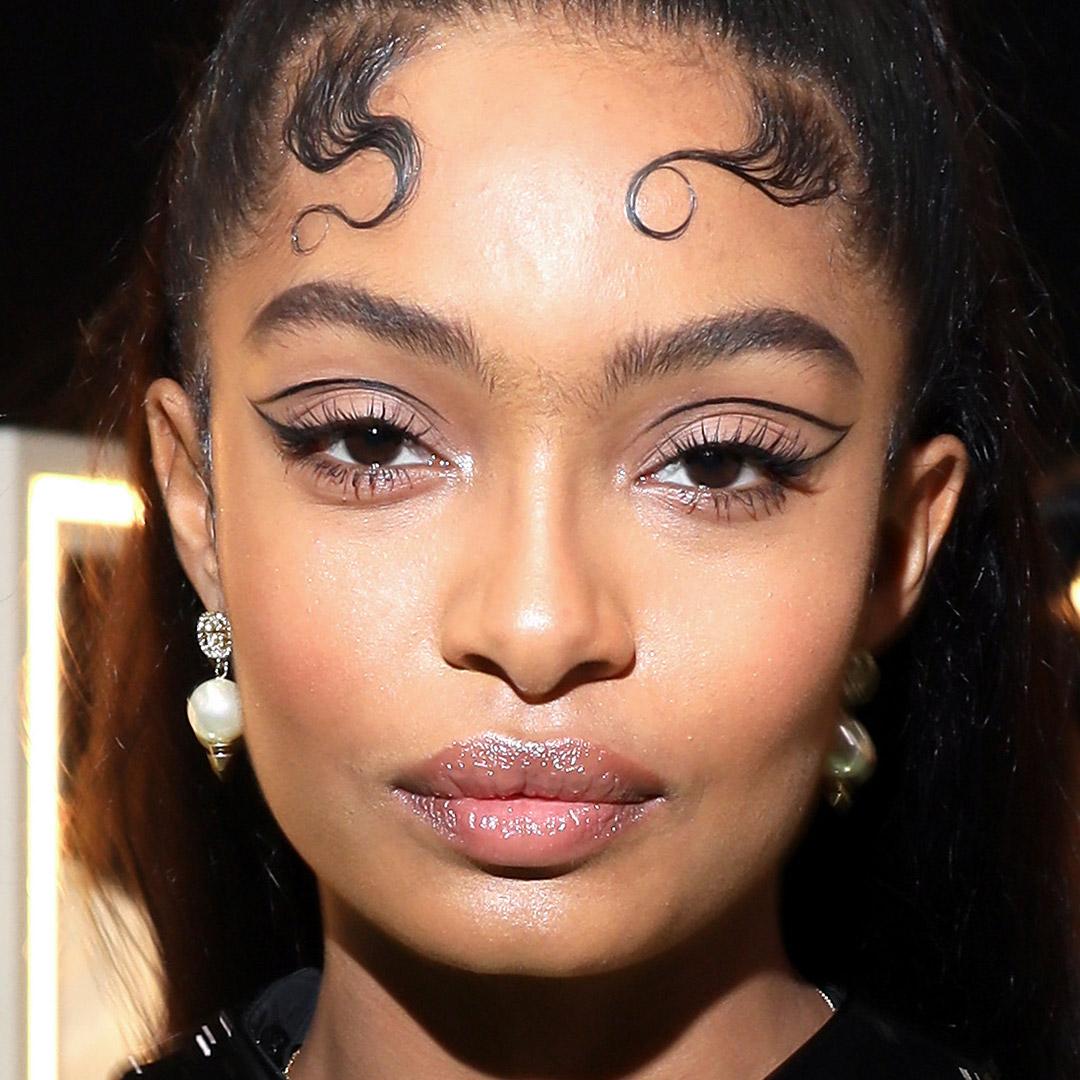 A photo of Yara Shahidi with a graphic eyeliner outline and nude eyeshadow and glossy lips Mobile