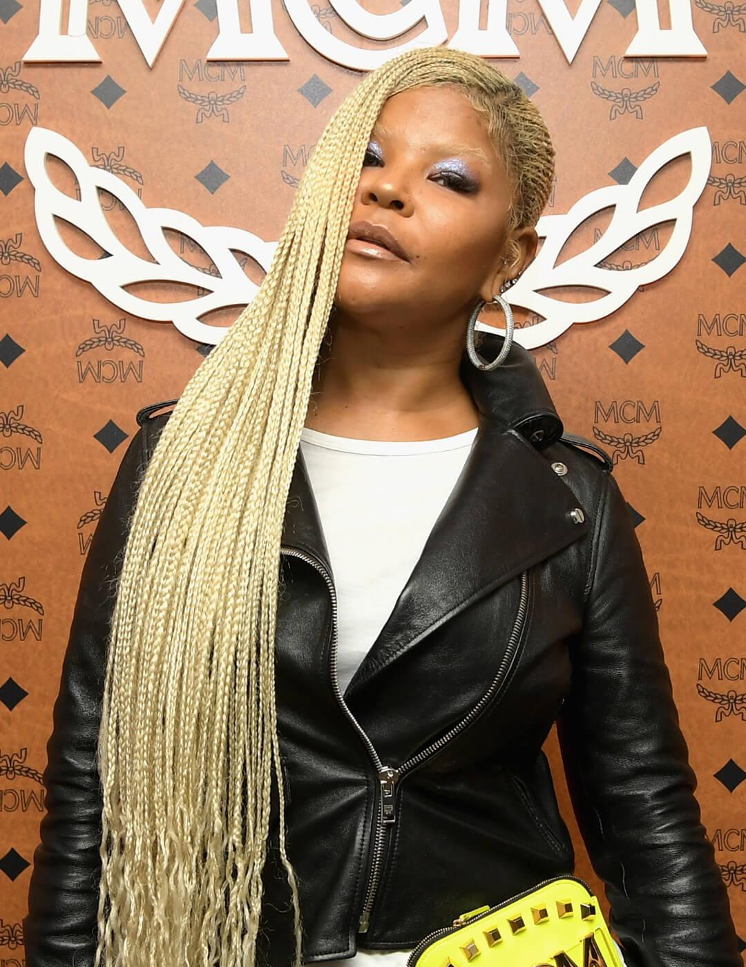 Misa Hylton rocking a blonde lemonade braids hairstyle, black leather jacket and white shirt inside, and silver eyeshadow makeup paired with nude lips Desktop
