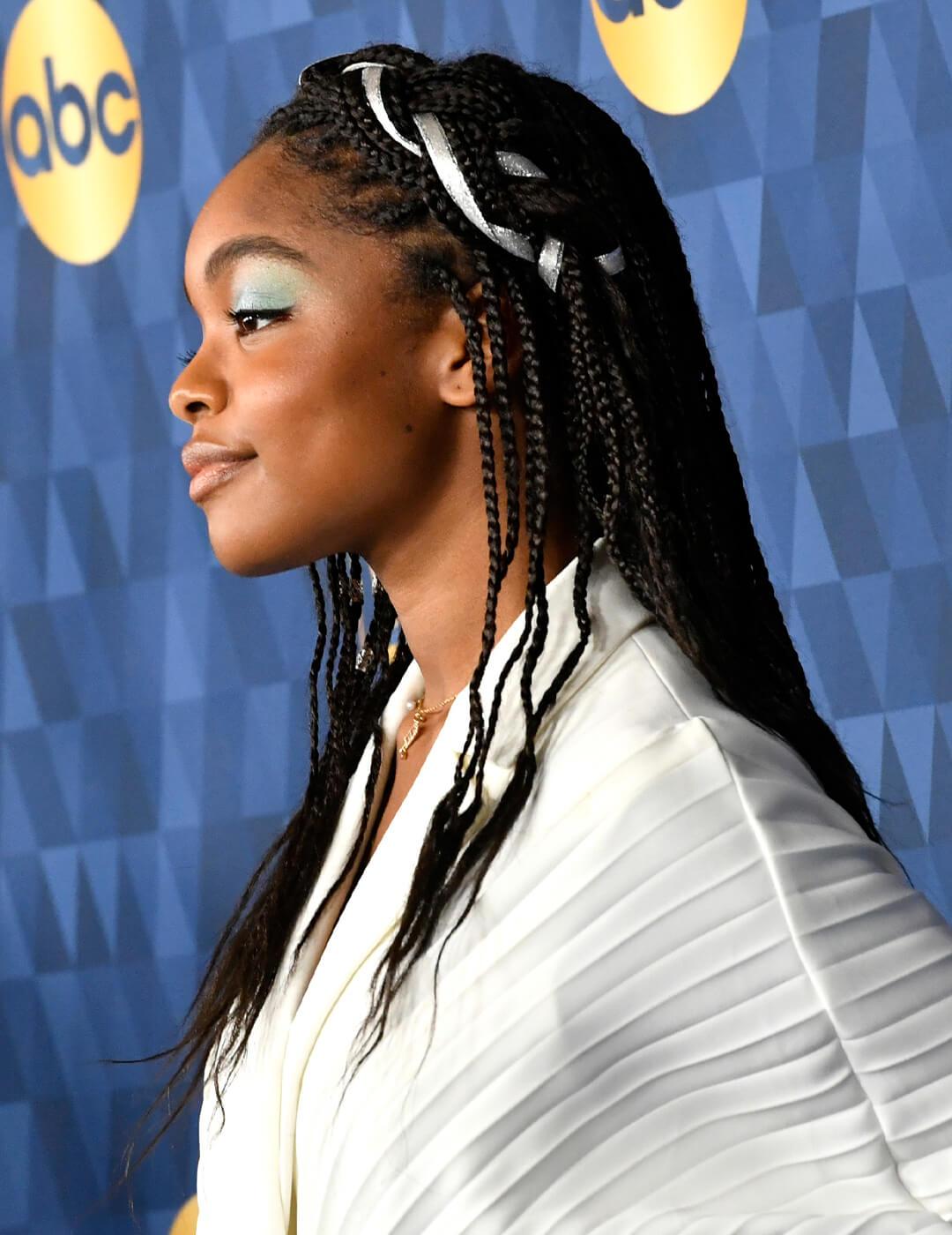 Marsai Martin in a white dress rocking a braided hairstyle with silver ribbon accent Mobile