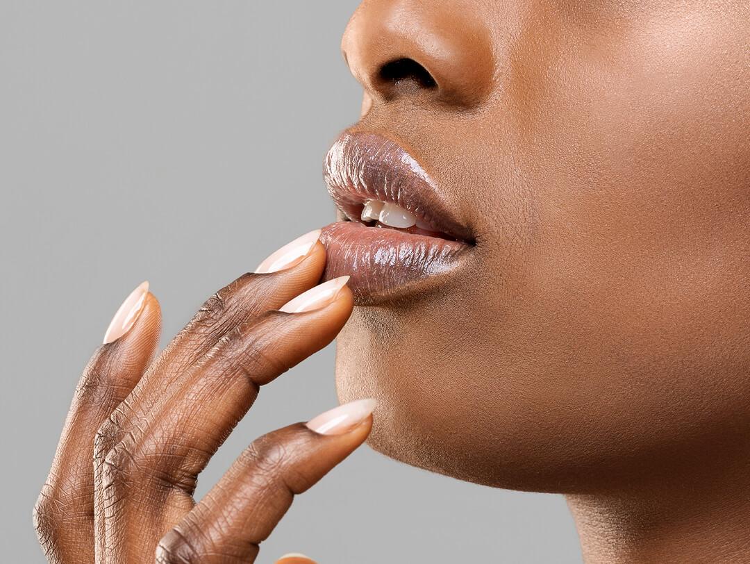 Close-up of a Black woman touching her lower lip with her fingers Desktop