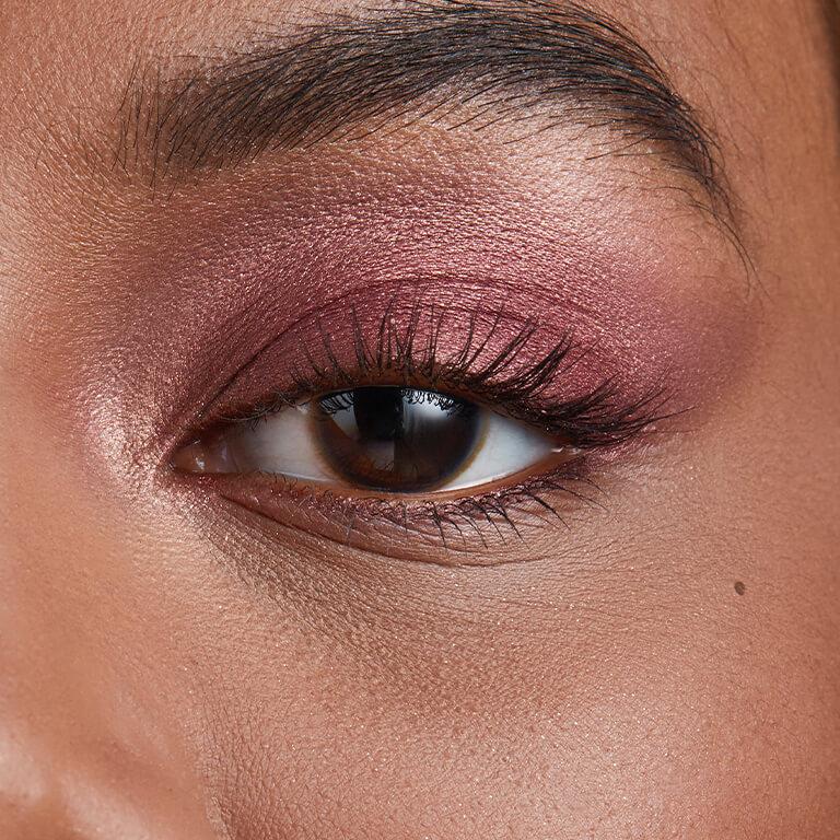 A closeup image of model Martine Fox's eye with dark, metallic berry eyeshadow Desktop