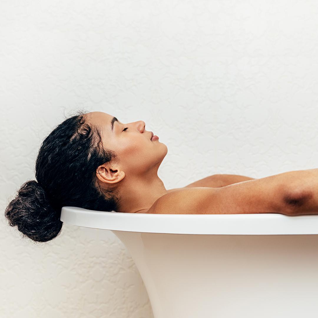 A photo of a woman with a bun hairstyle relaxing on a bathtub Desktop