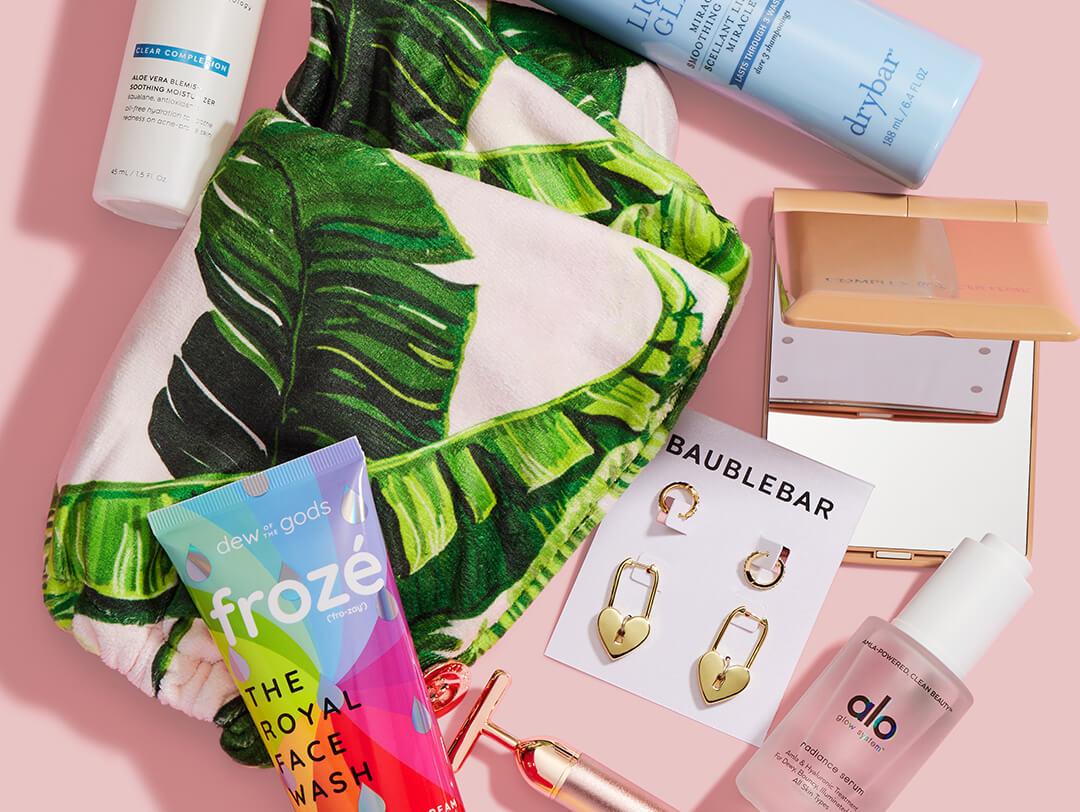 Beauty and makeup products from various brands scattered on light pink background Desktop