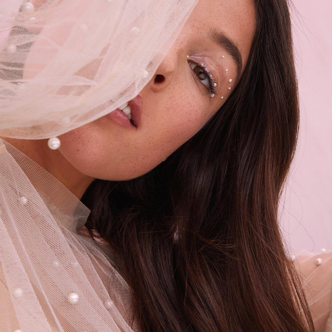 Close-up image of a model hiding behind her lacy outfit Mobile